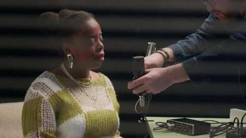 Process of Setting Up Microphone for Young Black Podcast Member in Studio