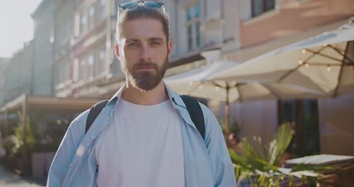 Camera Moving Side View of Handsome Young Bearded Man Standing Outside at Background of Pretty