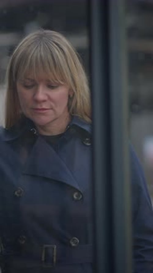 Woman Leaning Against Fence with Sad Expression