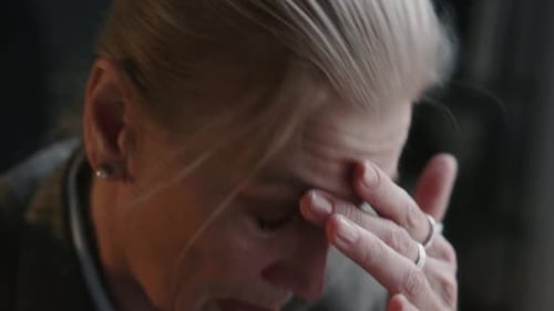 Tired Businesswoman Taking Glasses Off during Break in Office