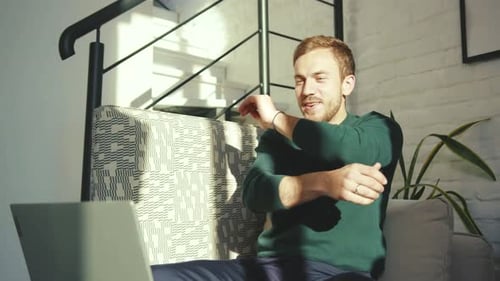 Man Celebrating Success with Laptop at Home