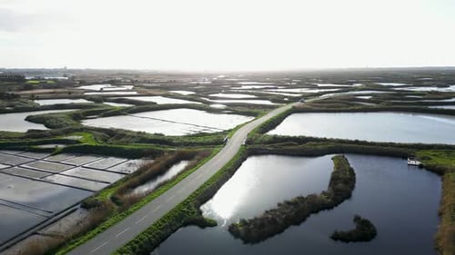 Scenic Landscape View of the Salt Marshes and a Car Driving on a Road