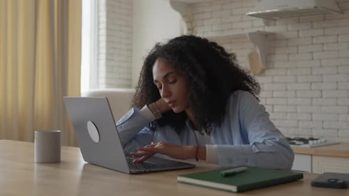 Woman Works on Laptop at Kitchen Table
