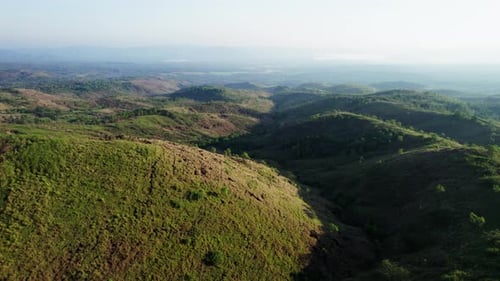 Aerial drone view of vast rolling hills and green valley at sunrise