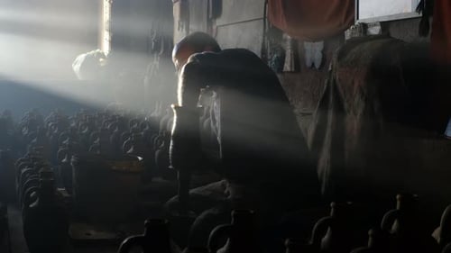 Potter Shapes Clay Jugs in Workshop