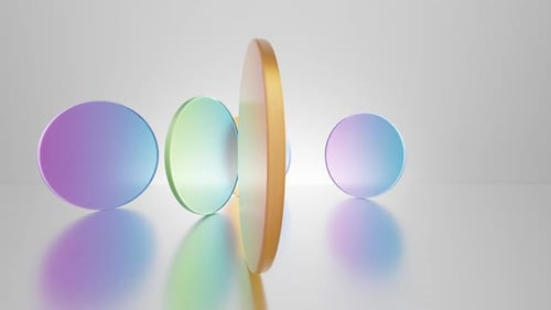 Multicolored translucent round glass blocks spin and rotate on a white background.