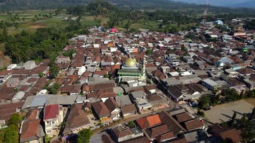 4K aerial footage of a beautiful mosque standing in the heart of a peaceful rural village, surrounde