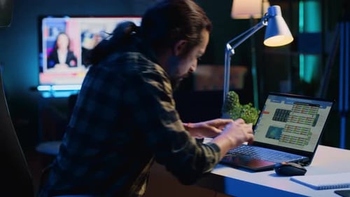 Man Working Late at Computer in Dimly Lit Room