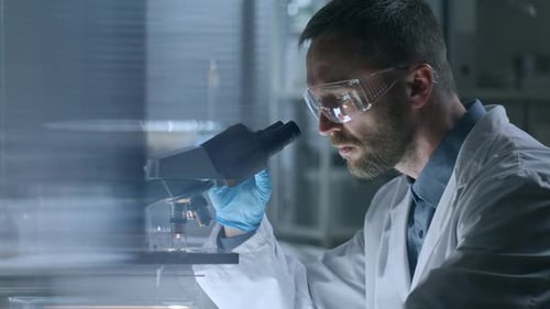 Scientist Using Microscope in Brightly Lit Lab