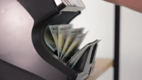 Money Counter Counts Stack of Hundred Dollar Bills
