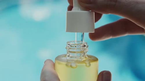 Dropping Essential Oil with Light Blue Background