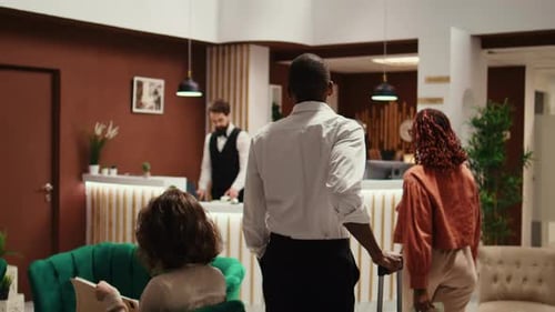 Couple Checking Into Stylish Hotel Reception