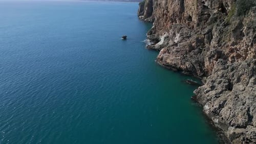 Aerial Shot the Camera Flies Forward Along a High Rocky Seashore