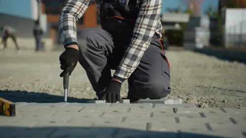 Worker Hammering Paving Stones in a Country Cottage Town