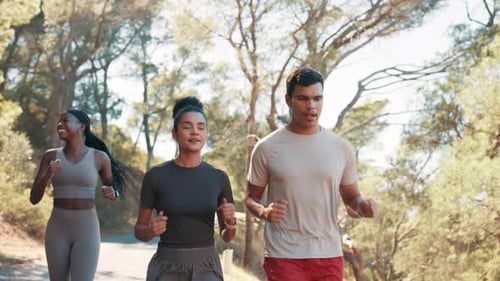 People Jogging Together Down Paved Road in Park