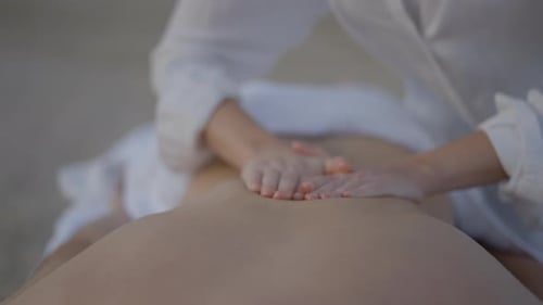Unknown Masseuse Performing Massage at the Beach
