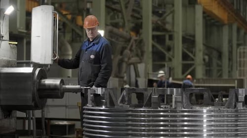 Skilled Industrial Worker Efficiently Operating Sophisticated Machinery Inside the Factory Stock