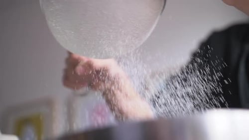 Flour Sifting Through Sieve into Bowl in Kitchen