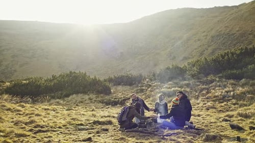 Groupe de routards se relaxant près d'un feu de camp