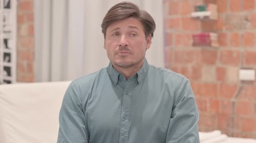 Man Checking Watch While Sitting Indoors