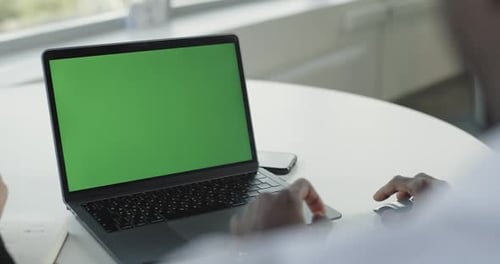 Office Firstperson View Dark Skinned Businessman Working on a Laptop with a Green Screen Shows