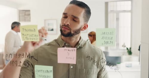 Planning, thinking and sticky note with a business man writing on a glass board in his office