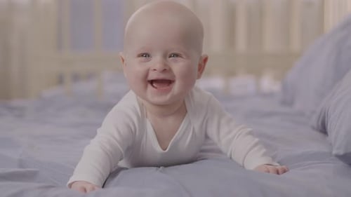 Adorable Baby Lying on Bed Smiling