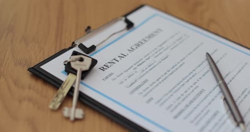 Closeup View of a Rental Agreement Document with Key and a Pen Placed on Top Property Rental Leasing