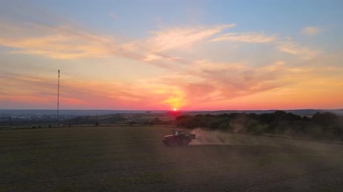 Vue aérienne d'un tracteur labourant un champ agricole préparant le sol pour l'ensemencement en été