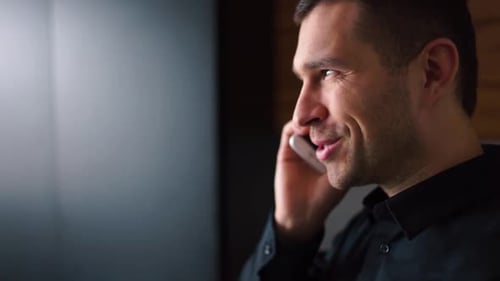 Side View Video of Young Businessman in Black Shirt Talking on Phone and Smile