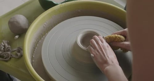 Un potier fabriquant une tasse sur un tour de potier.
