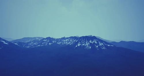 Majestic Mountain Range Covered in Snow Under a Clear Blue Sky