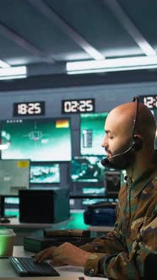 Man Monitoring Data in Dark Control Room