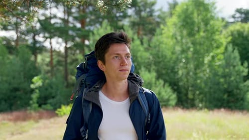 Blackhaired Guy Hiker geht gerne lächelnd im Wald spazieren
