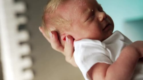 Joli nouveau-né qui dort doucement sur la main de maman. Gros plan. Faire signe à un bébé pour le calmer.