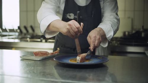 Chef plating seafood dish in restaurant kitchen