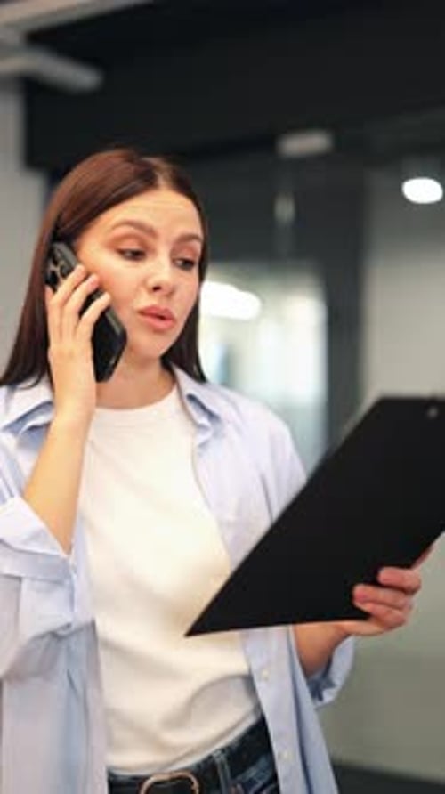 Woman Talking on Phone While Holding Documents