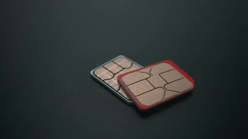 Close-up of Two SIM Cards on a Dark Surface – 4K Technology Footage