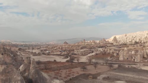 Rugged barren landscape dotted with fairy chimneys, conned rock like structures in Cappadocia, Turke