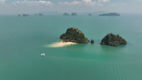 Speedboat Crossing Serene Blue Waters Surrounding Tropical Islands Under Clear Sky