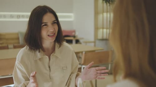 Deux belles jeunes femmes sont assises dans un café et se parlent. Deux amies se sont rencontrées dans un café