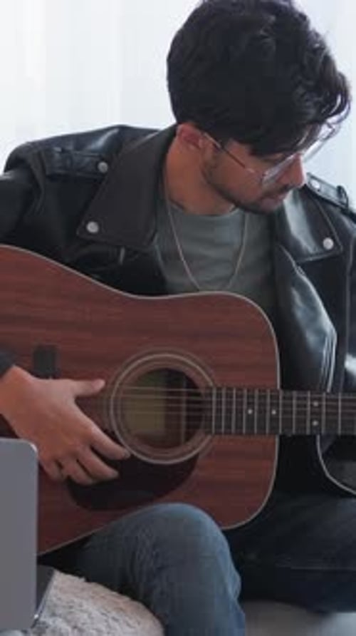 Man Plays Acoustic Guitar at Home