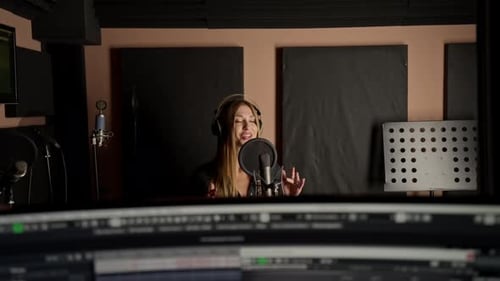 On the sound engineer's computer monitor sound tracks for mixing a new soundtrack that girl sings