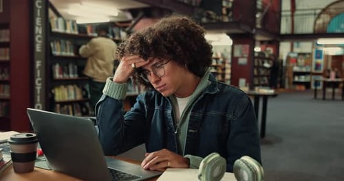 Man, headache and student in library, laptop and stress with deadline for assignment