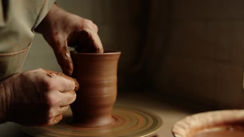 Unbekannter Töpfer formt Tongefäß auf Töpferscheibe in traditioneller Werkstatt