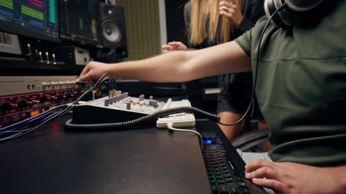 a girl singer and a male sound engineer work together in recording studio to create a new song
