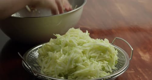 View Back on the Peel the Zucchini Closeup A Chef Transfers Sliced Zucchini but First Squeezes the
