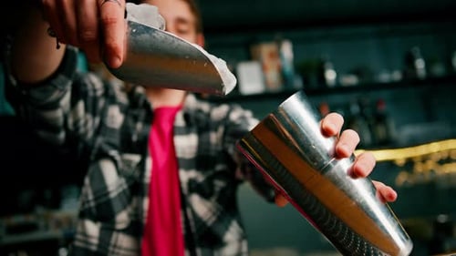 Bartender Adding Ice to Cocktail Shaker at Bar
