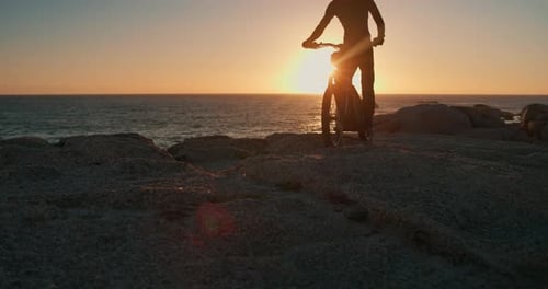 Person, hill and motorbike with sunset for travel, adventure or riding on rocks