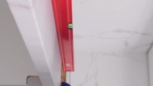 Vidéo verticale d'un homme inspecte la cuisinière avec un Spirit Level
